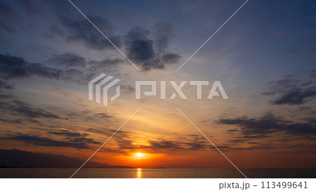 夕方の空に沈んでいく夕陽と、たくさんの雲 夕方の空に沈んでいく夕陽と、たくさんの雲 113499641