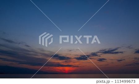 夕方の空に沈んでいく夕陽と、ブルーモーメント(マジックアワー) 113499673