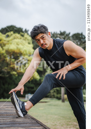 屋外で柔軟体操をする男性 113499849