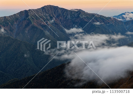 南アルプス・仙丈ヶ岳から見る残照の間ノ岳と農鳥岳 113500718