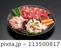焼き肉素材の盛り合わせ・黒い皿に盛りつけられた高級焼き肉素材・牛肉、鶏肉、牛ホルモンの盛り合わせ 113500817