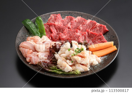焼き肉素材の盛り合わせ・黒い皿に盛りつけられた高級焼き肉素材・牛肉、鶏肉、牛ホルモンの盛り合わせ 113500817