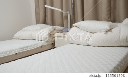 シーツがかけられていないツインベッド 113501208