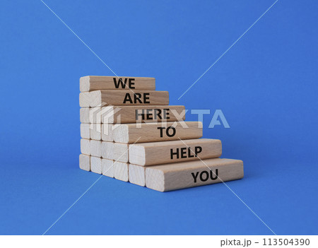We are here to help you symbol. Concept words we are here to help you on wooden blocks. Beautiful blue background. Business and we are here to help you concept. Copy space. 113504390