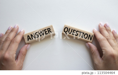 Answer or Question symbol. Concept word Answer or Question on wooden blocks. Businessman hand. Beautiful white background. Business and Answer or Question concept. Copy space Answer or Question symbol. Concept word Answer or Question on wooden blocks. Businessman hand. Beautiful white background. Business and Answer or Question concept. Copy space 113504464