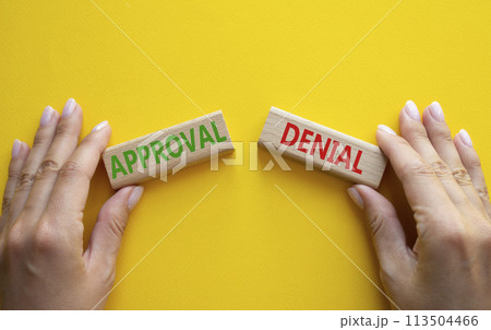 Approval or Denial symbol. Concept word Approval or Denial on wooden blocks. Businessman hand. Beautiful yellow background. Business and Approval or Denial concept. Copy space Approval or Denial symbol. Concept word Approval or Denial on wooden blocks. Businessman hand. Beautiful yellow background. Business and Approval or Denial concept. Copy space 113504466