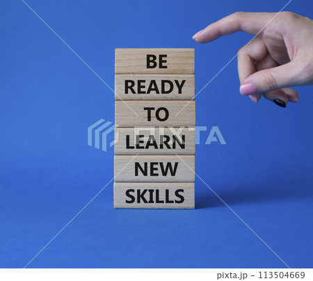 Learn new skills symbol. Concept words Be ready to Learn new skills on wooden blocks. Beautiful blue background. Businessman hand. Business and Learn new skills concept. Copy space. 113504669