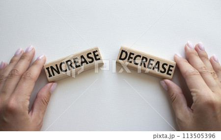 Increase or Decrease symbol. Concept word Increase or Decrease on wooden blocks. Businessman hand. Beautiful white background. Business and Increase or Decrease concept. Copy space 113505396