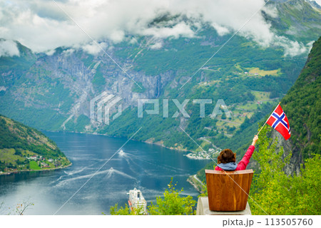 Tourist over Geirangerfjord holds norwegian flag 113505760