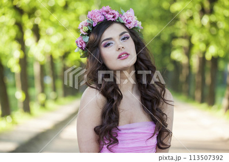 Gorgeous healthy woman with makeup and long wavy dark brown hairstyle with flowers 113507392