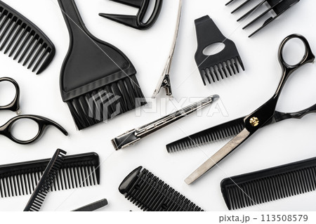Black hairdressing tools and various hairbrushes on white background 113508579