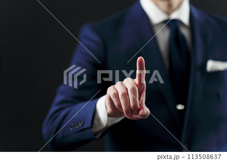 黒背景で指差しをするビジネスマンの手元 113508637