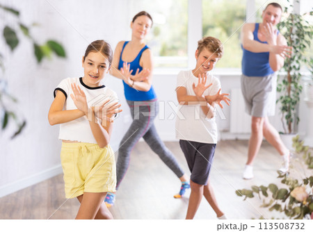 Parents together with their children learn how to dance salsa or boogie-woogie in dance class 113508732