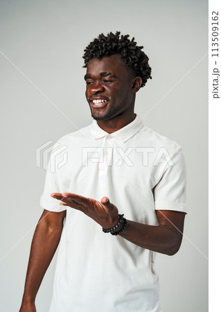 A man wearing a white shirt is seen making a gesture with his hands, expressing something nonverbally. 113509162