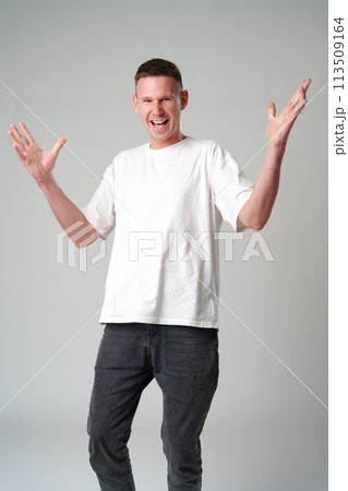 Portrait of surprised young man with shocked facial expression against gray background 113509164