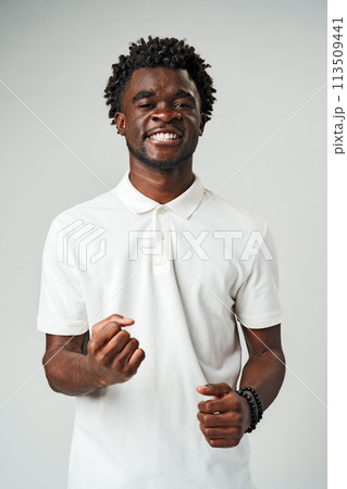 A man wearing a white shirt is smiling happily, displaying a sense of joy and contentment. 113509441