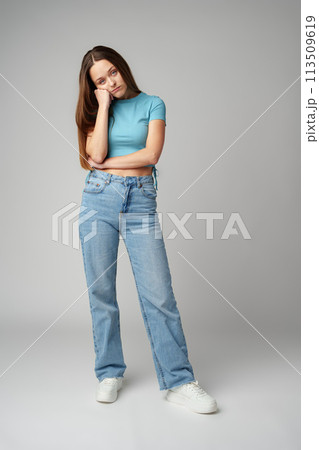 Young woman wearing casual clothes looking tired and bored on gray background 113509619