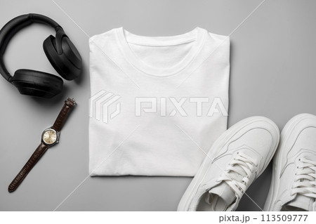 White T-shirt and sneakers, headphones and watch on gray background top view White T-shirt and sneakers, headphones and watch on gray background top view 113509777