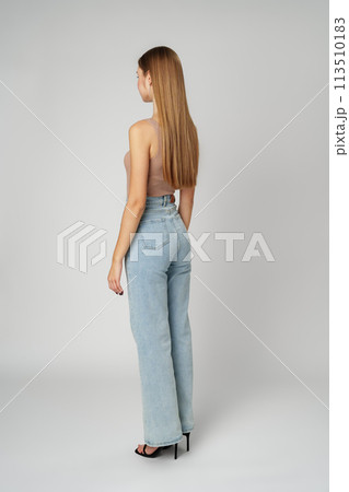 Back view full length photo of young woman with long hair on gray background 113510183