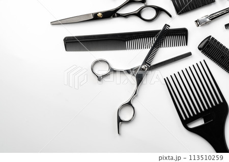 Black hairdressing tools and various hairbrushes on white background Black hairdressing tools and various hairbrushes on white background 113510259