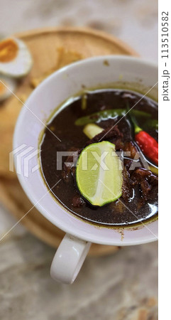 Rawon or Indonesian black beef soup, black color are from indonesian nut called kluwek. Served with lime, chili paste, salted egg, and tempe cracker. Perfect for recipe, article, or any cooking Rawon or Indonesian black beef soup, black color are from indonesian nut called kluwek. Served with lime, chili paste, salted egg, and tempe cracker. Perfect for recipe, article, or any cooking 113510582
