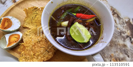 Rawon or Indonesian black beef soup, black color are from indonesian nut called kluwek. Served with lime, chili paste, salted egg, and tempe cracker. Perfect for recipe, article, or any cooking Rawon or Indonesian black beef soup, black color are from indonesian nut called kluwek. Served with lime, chili paste, salted egg, and tempe cracker. Perfect for recipe, article, or any cooking 113510591