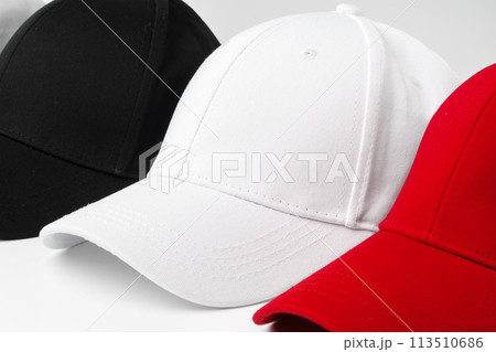 Lineup of Four Blank Baseball Caps in Red, White, and Black on a White Background 113510686