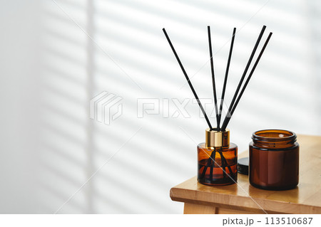 Aromatherapy Reed Diffuser and Scented Candle on a Wooden Table in a Cozy Room 113510687