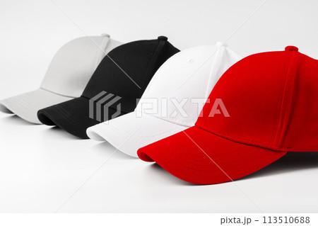 Lineup of Four Blank Baseball Caps in Red, White, and Black on a White Background 113510688