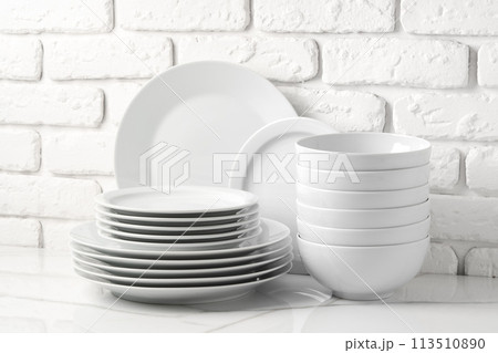 Set of dishes on table against brick wall background Set of dishes on table against brick wall background 113510890