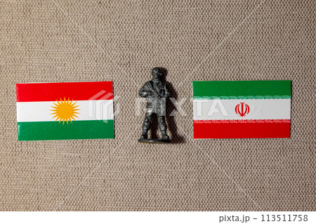 A soldier figurine on the background of the flags of Iran and Kurdistan 113511758