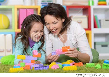 Mom and daughter playing on the floor  113512076
