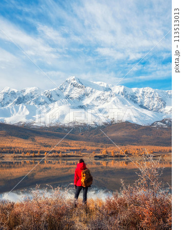Back view of traveler in a red looking to mountain lake Back view of traveler in a red looking to mountain lake 113513013