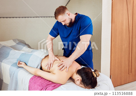 To relieve back pain, woman receives deep tissue massage therapy, where massage therapist kneads her muscles with firm pressure. To relieve back pain, woman receives deep tissue massage therapy, where massage therapist kneads her muscles with firm pressure. 113516888