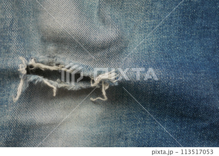 blue jean texture with a hole and ripped threads showing blue jean texture with a hole and ripped threads showing 113517053