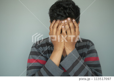 Close up of sad man covering face with hand. 113517097