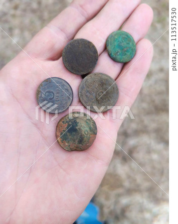 Hand holding vintage rusty dirty coins. Hand holding vintage rusty dirty coins. 113517530