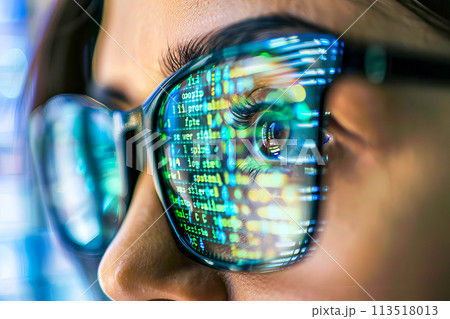 Detailed view of a persons face with glasses and focused eyes into a computer monitor. 113518013