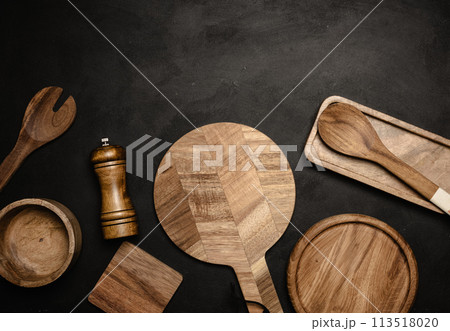 Various wooden kitchen utensils on black background, top view. 113518020