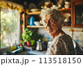 An older woman stands next to a window in a kitchen, looking outside and preparing a meal. 113518150