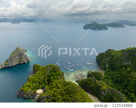 Boats and Kayaks over the blue sea. Miniloc and Twin Rocks in El Nido, Palawan. Philippines. Boats and Kayaks over the blue sea. Miniloc and Twin Rocks in El Nido, Palawan. Philippines. 113518866