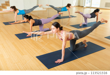 Young woman practicing balancing yoga posture Dandayamna Bharmanasana 113521316