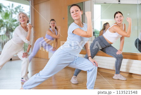 Active middle-aged woman practicing aerobic dance in training hall Active middle-aged woman practicing aerobic dance in training hall 113521548