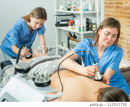 Women doctors performing hardware body procedure to female patient Women doctors performing hardware body procedure to female patient 113521730