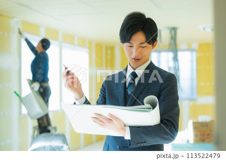 工事現場で指示するスーツの男性 工事現場で指示するスーツの男性 113522479