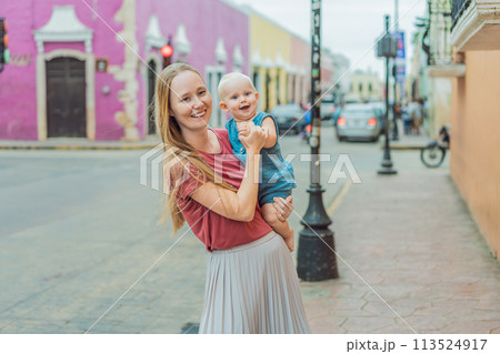 Mother and baby son tourists explore the vibrant streets of Valladolid, Mexico, immersing herself in the rich culture and colorful architecture of this charming colonial town Mother and baby son tourists explore the vibrant streets of Valladolid, Mexico, immersing herself in the rich culture and colorful architecture of this charming colonial town 113524917
