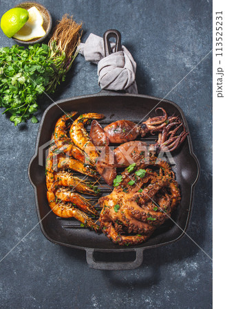 Grilled spimps, squids and octopus in cast iron grill pan Grilled spimps, squids and octopus in cast iron grill pan 113525231