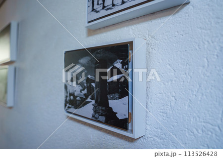 Framed black and white photo of Zermatt, Swiss ski resort, on textured white wall. Modern frame, sophisticated ambiance, suggested luxury hotel setting. Framed black and white photo of Zermatt, Swiss ski resort, on textured white wall. Modern frame, sophisticated ambiance, suggested luxury hotel setting. 113526428