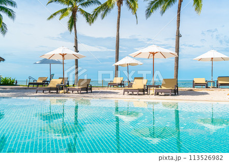 Beautiful tropical beach and sea with umbrella and chair around swimming pool in hotel resort Beautiful tropical beach and sea with umbrella and chair around swimming pool in hotel resort 113526982