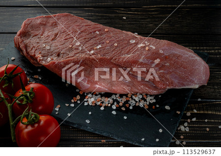 Raw beef steak with spices on a dark slate, stoneselective focus 113529637